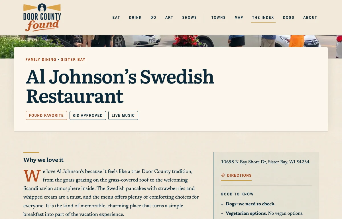 A place page for Al Johnson&rsquo;s Swedish Restaurant: the photograph runs behind a card carrying the category and town, the name, and badges reading Found Favorite, Kid Approved and Live Music, above a Why we love it paragraph beside a panel with the address, a directions link, and good-to-know notes on dogs and vegetarian options.