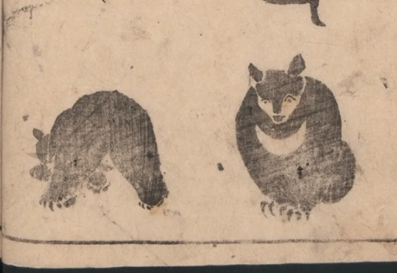 A woodblock page of two bears, each one dark shape on short legs with nothing drawn inside it.