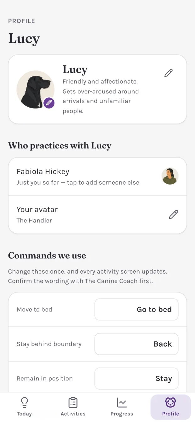 The Profile tab: Lucy&rsquo;s card noting she gets over-aroused around arrivals, who practices with her, and Commands we use &mdash; move to bed reads &ldquo;Go to bed,&rdquo; stay behind boundary reads &ldquo;Back,&rdquo; remain in position reads &ldquo;Stay,&rdquo; above a line asking you to confirm the wording with the trainer first.